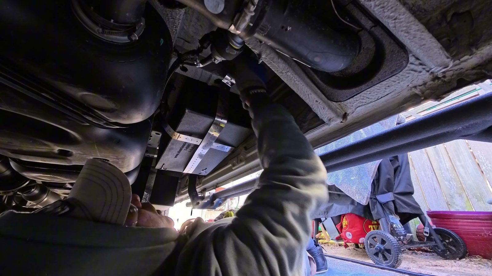 Black gray water tank strapped under the van with stainless steel straps