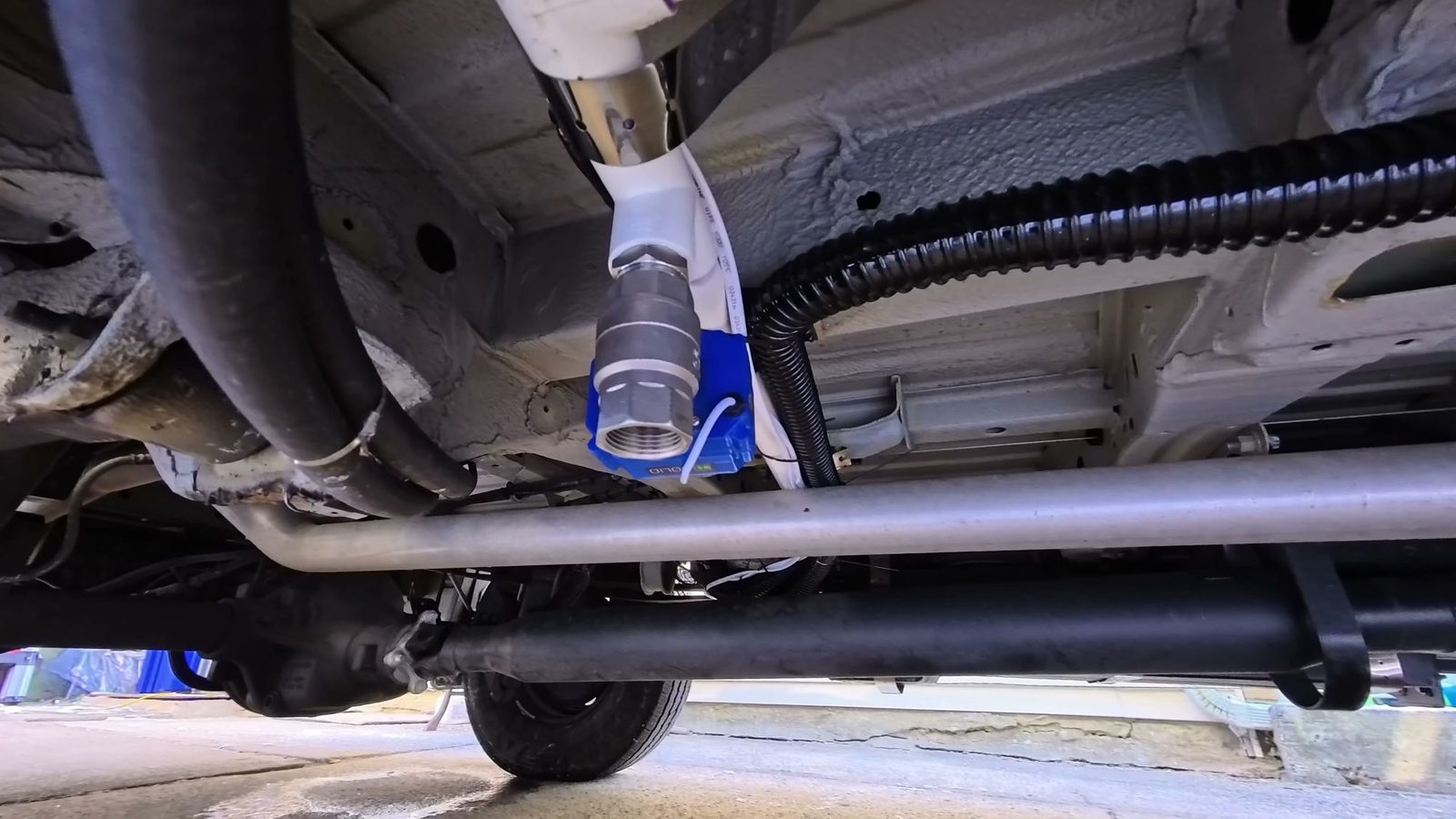 Blue-handled ball valve on the drain line under the van