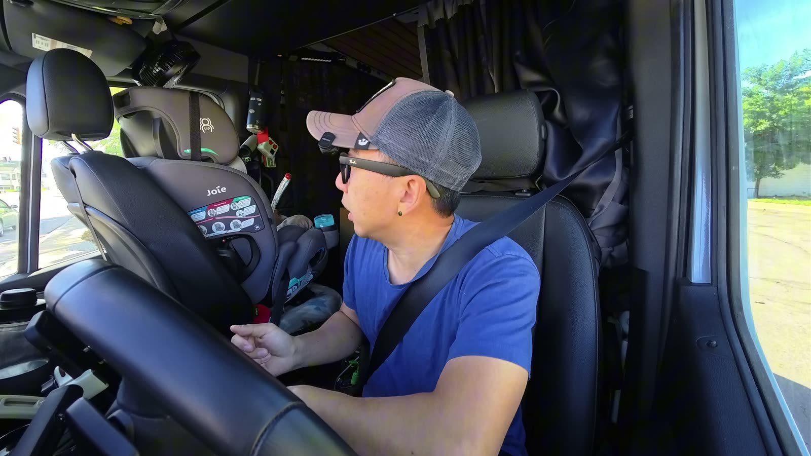 Michael at a fuel stop in the van, turning to check on Archie in his car seat