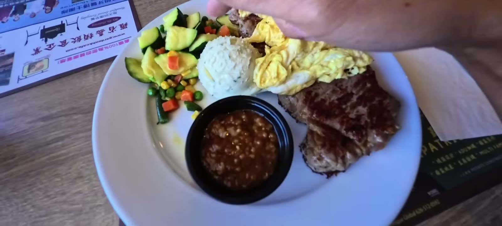 A steak and eggs breakfast plate with rice and vegetables at a Hong Kong style cafe