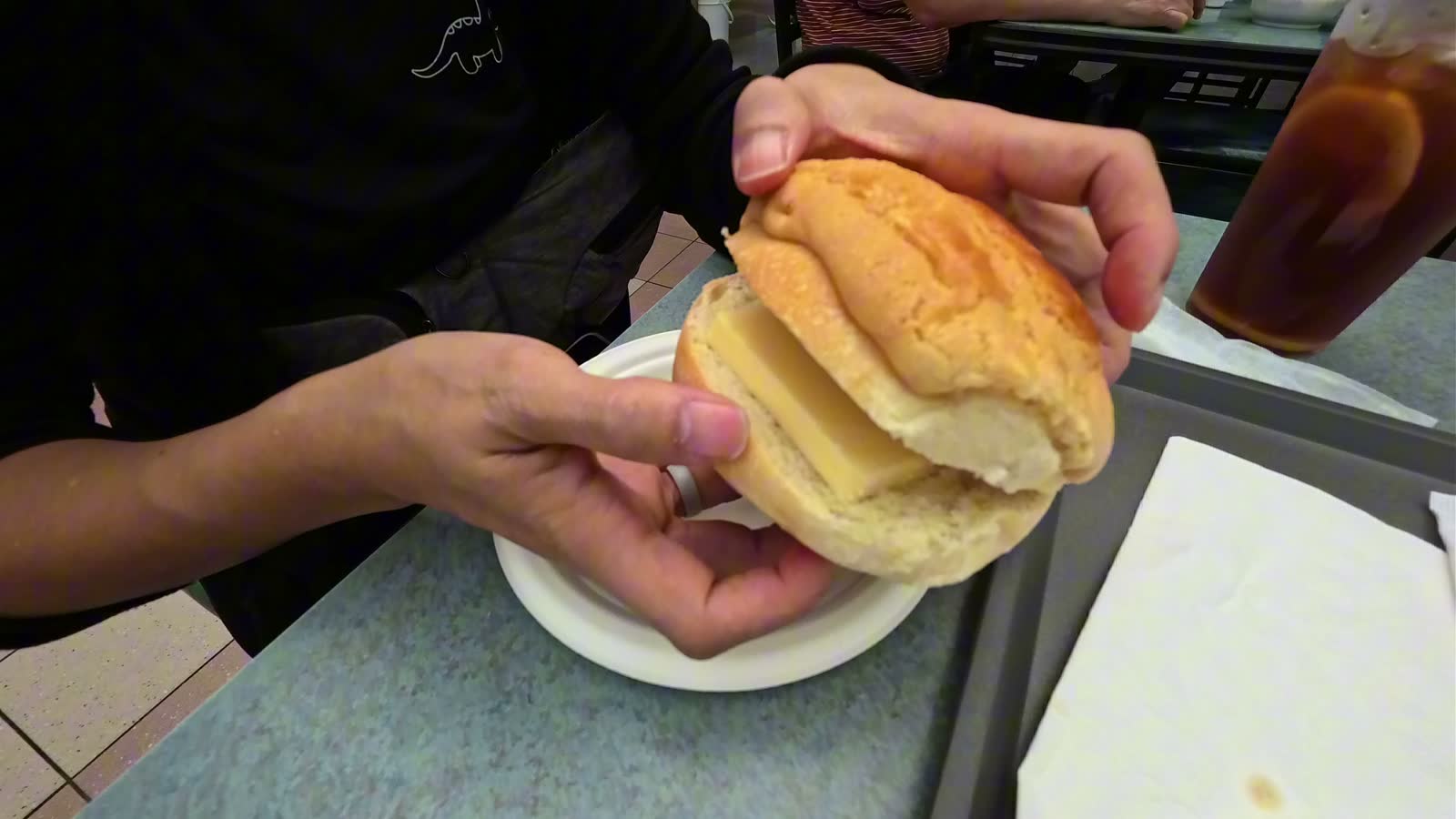 Michael holding a pineapple bun split open with a thick slice of butter inside