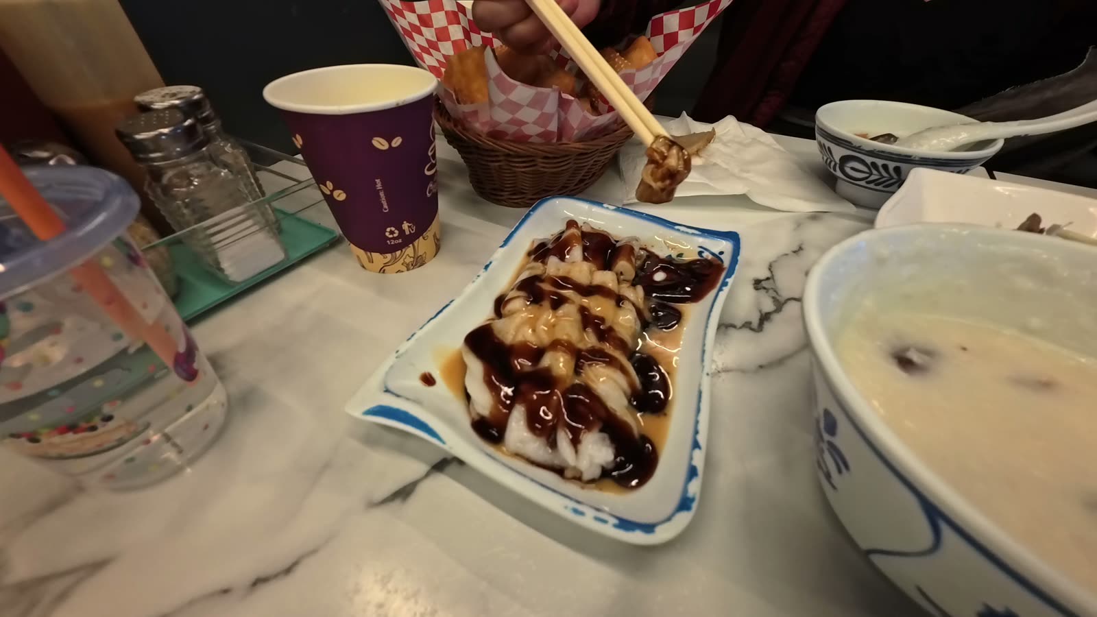 A plate of steamed rice rolls covered in soy, hoisin and peanut sauce