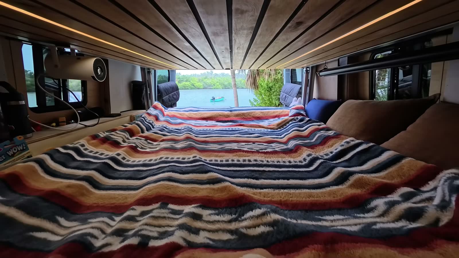 Our van’s sofa folded out into a full-size bed, looking toward the open back doors and the water