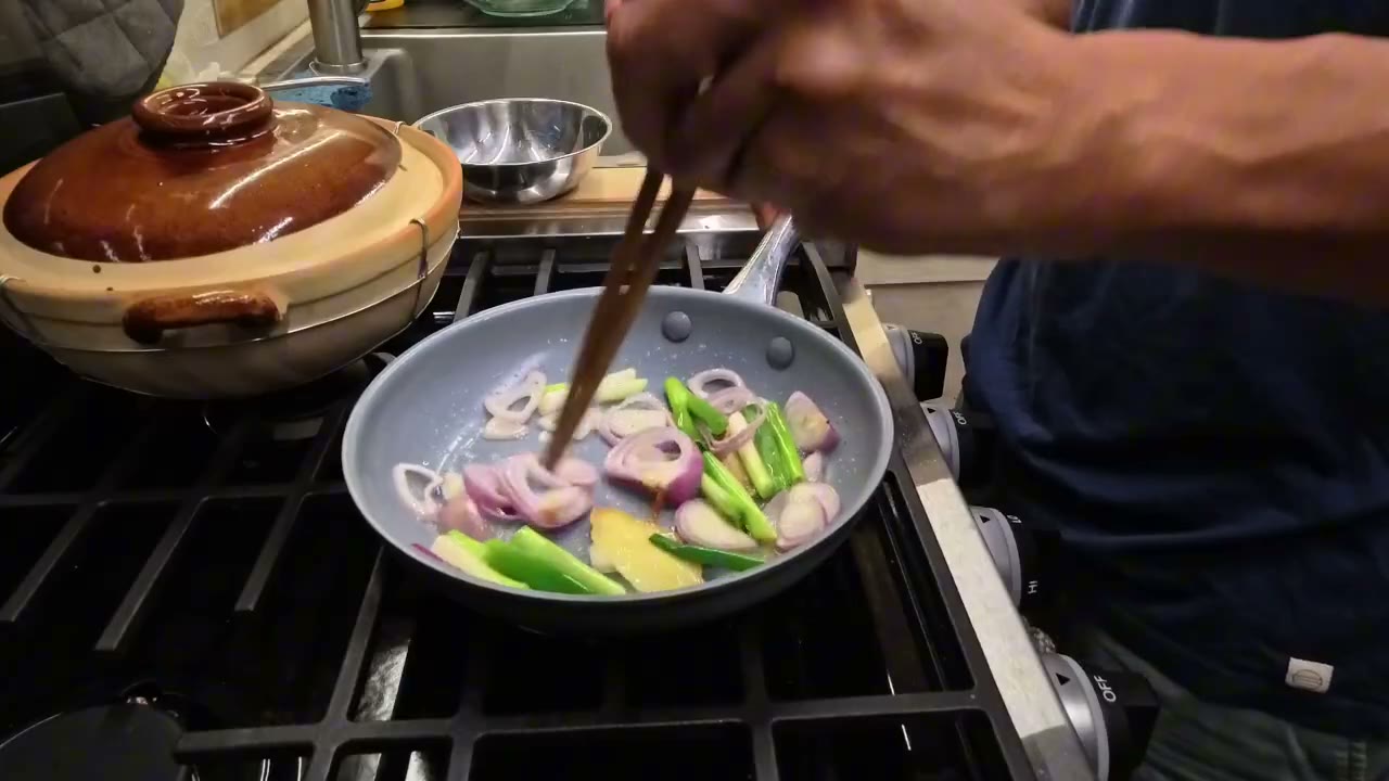 Cooking in the van kitchen next to a clay pot