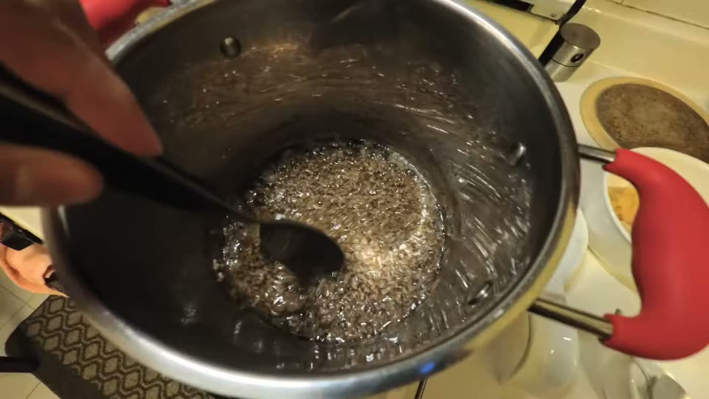 A pot of melted beef tallow simmering on the stove, almost clear