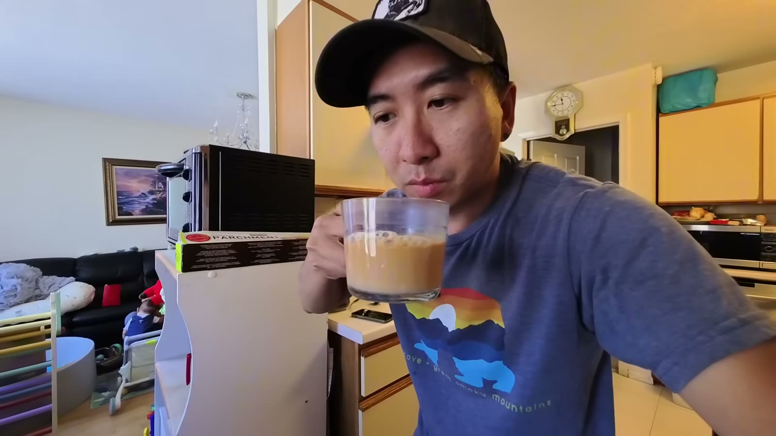 Michael taking his first sip of homemade Hong Kong milk tea from a glass mug in his mom’s kitchen