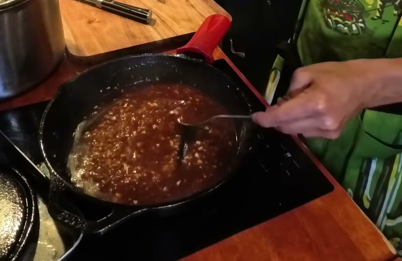 Garlic sauce bubbling in a cast iron pan, thickened with cornstarch