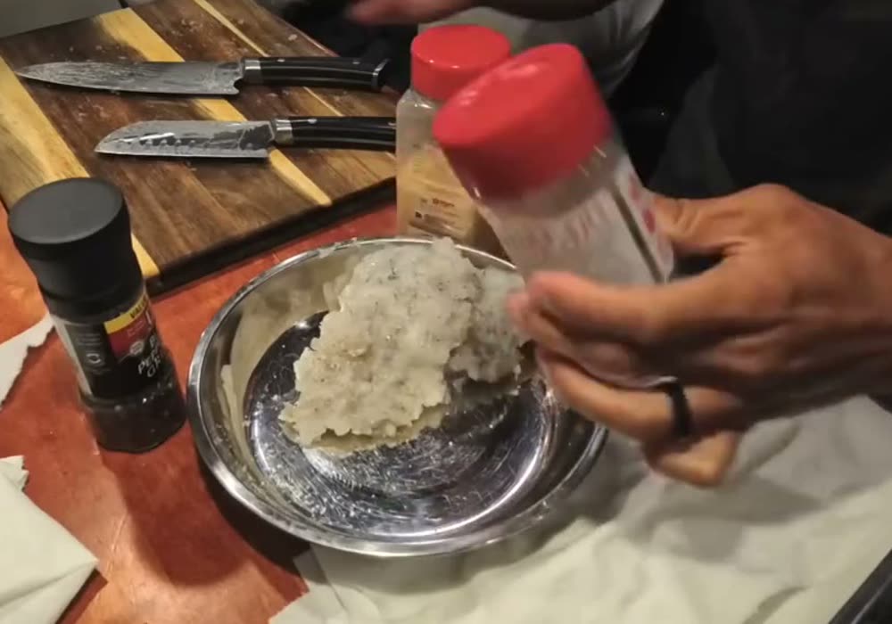 Seasoning chopped shrimp in a metal bowl on the van counter to make shrimp paste