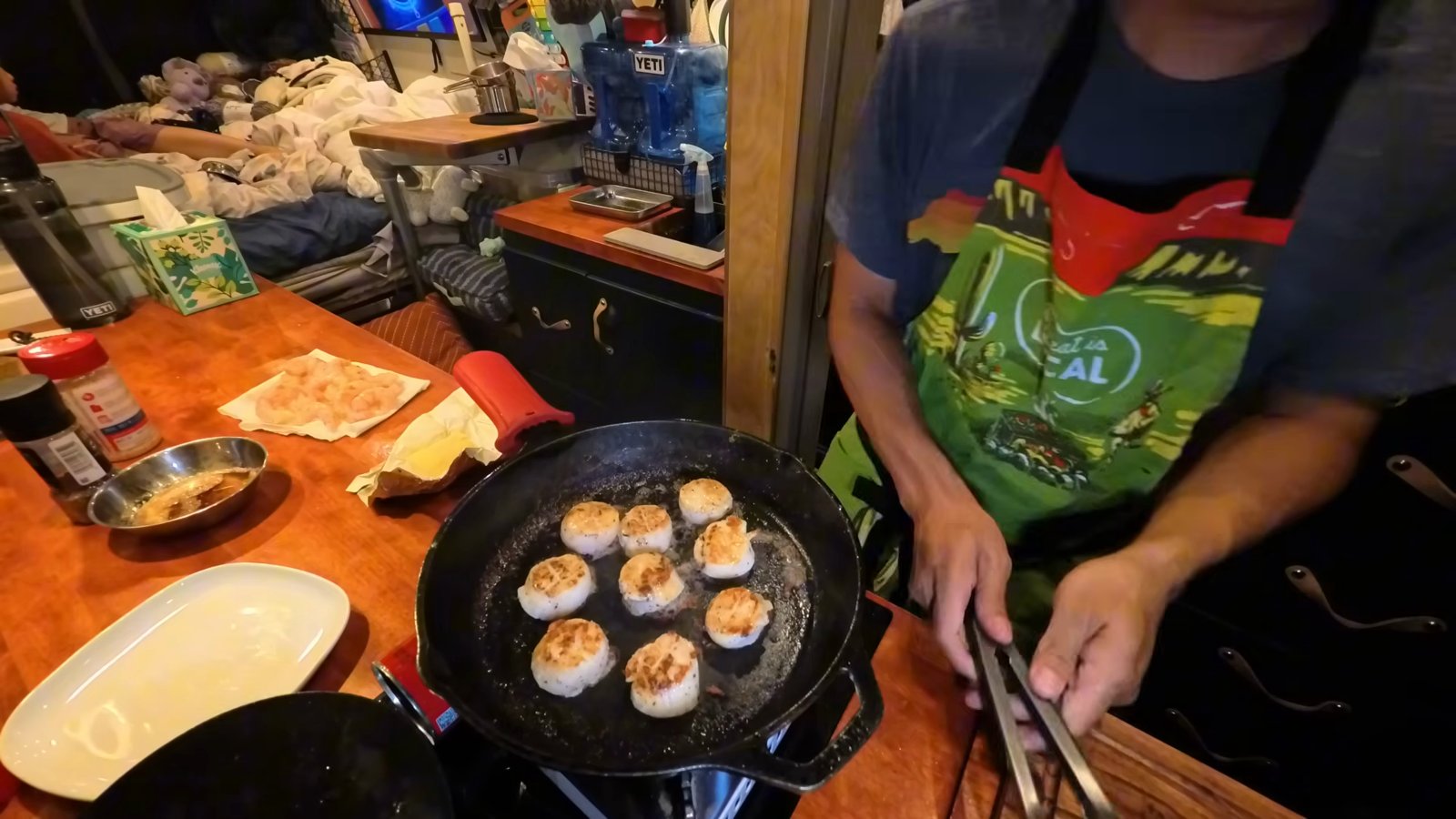 Scallops searing in a cast iron pan on the van stove