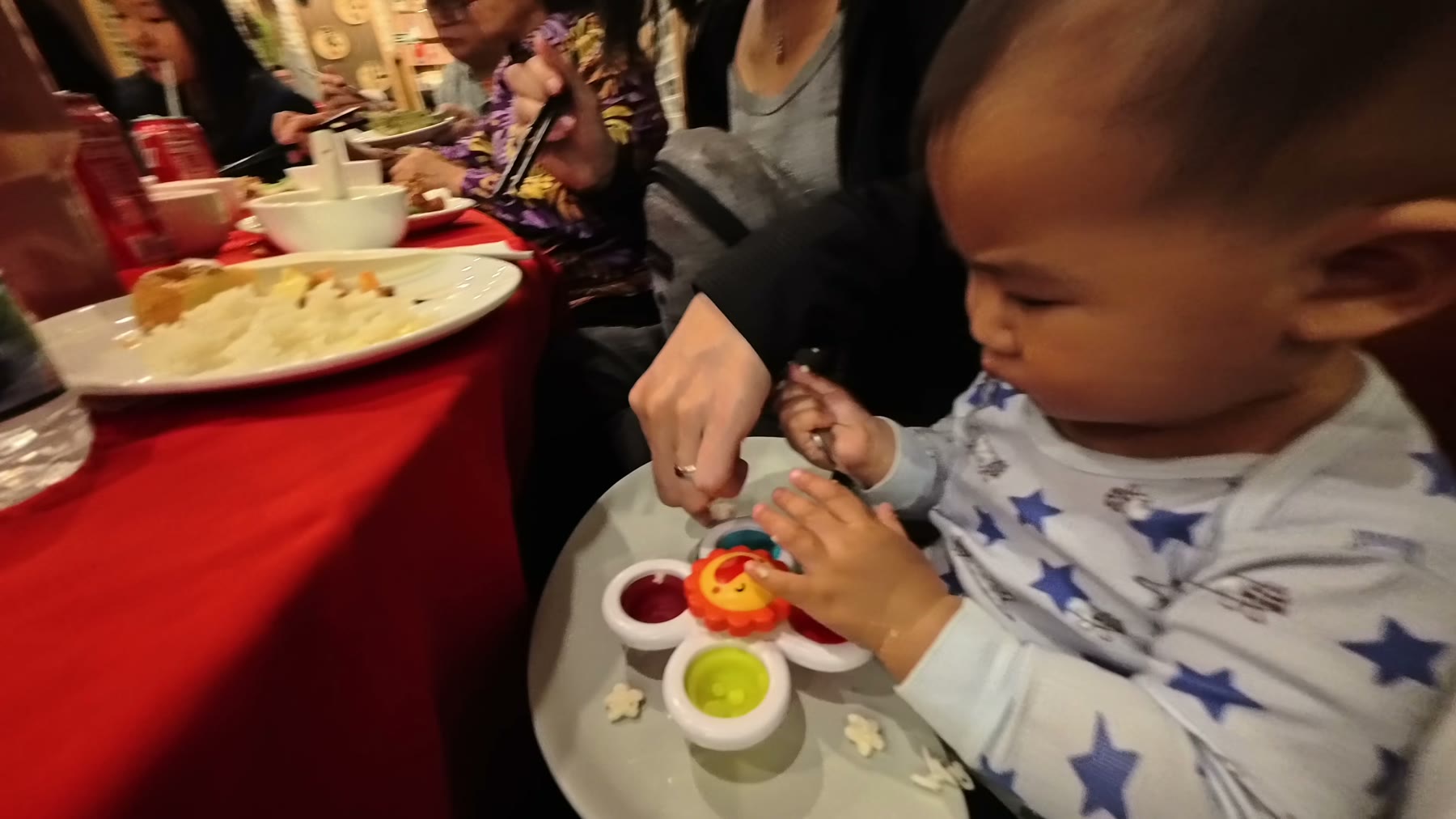 Spencer eating with chopsticks at a family dinner